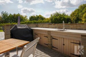 ...großer, teilweise überdachter Terrasse und Außenküche